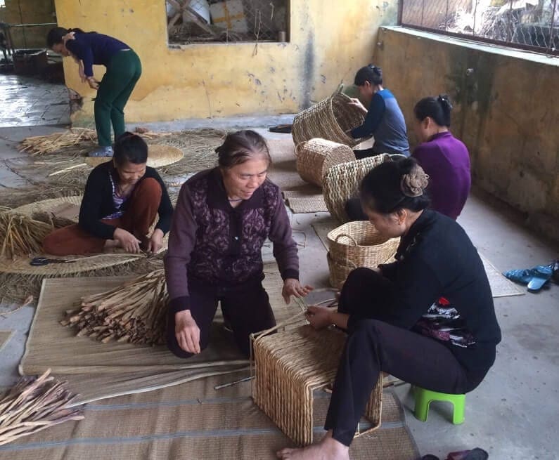 An artisan hand-weaving a natural fiber basket in Nga Son.