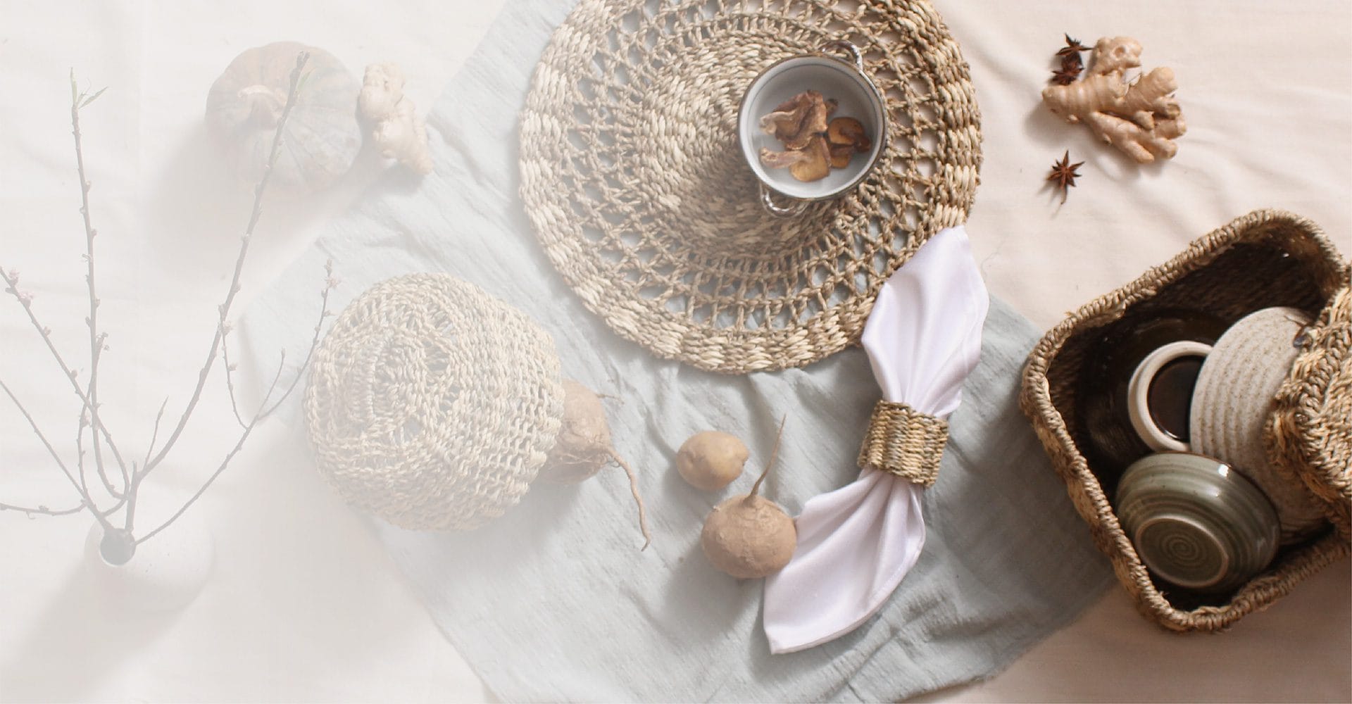 Soft table setting with a woven placemat, napkin ring and a seagrass tray of cups