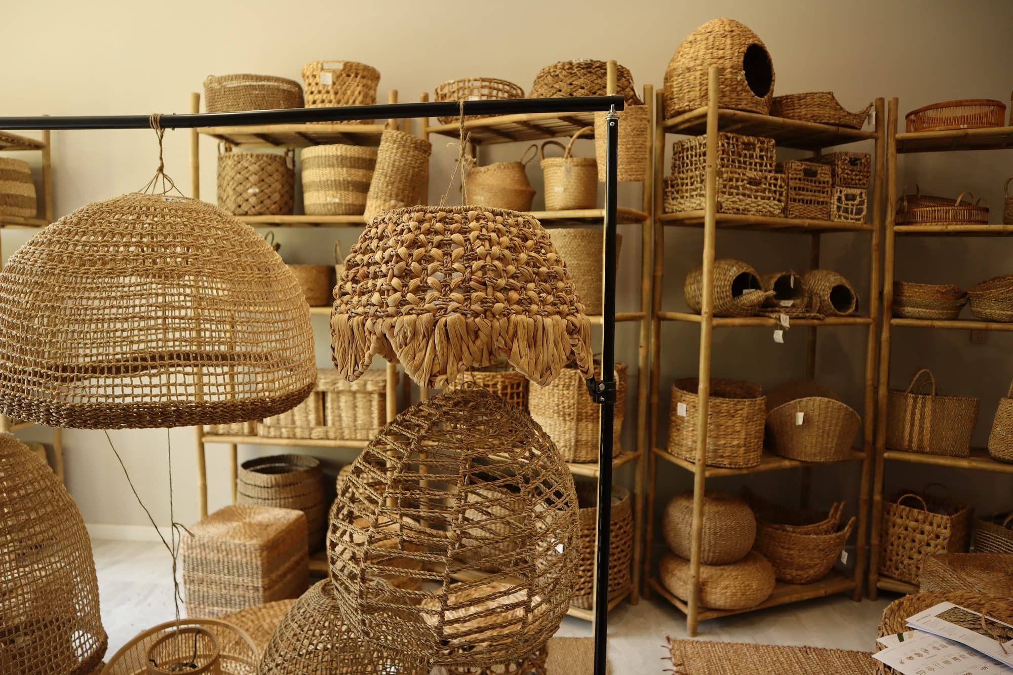 Showroom corner with woven pendant lampshades and shelves of baskets